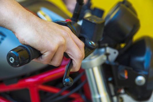 Rider performing maintenance on a Royal Enfield motorcycle, checking engine oil and chain with genuine Royal Enfield accessories from Torque and Trail.
